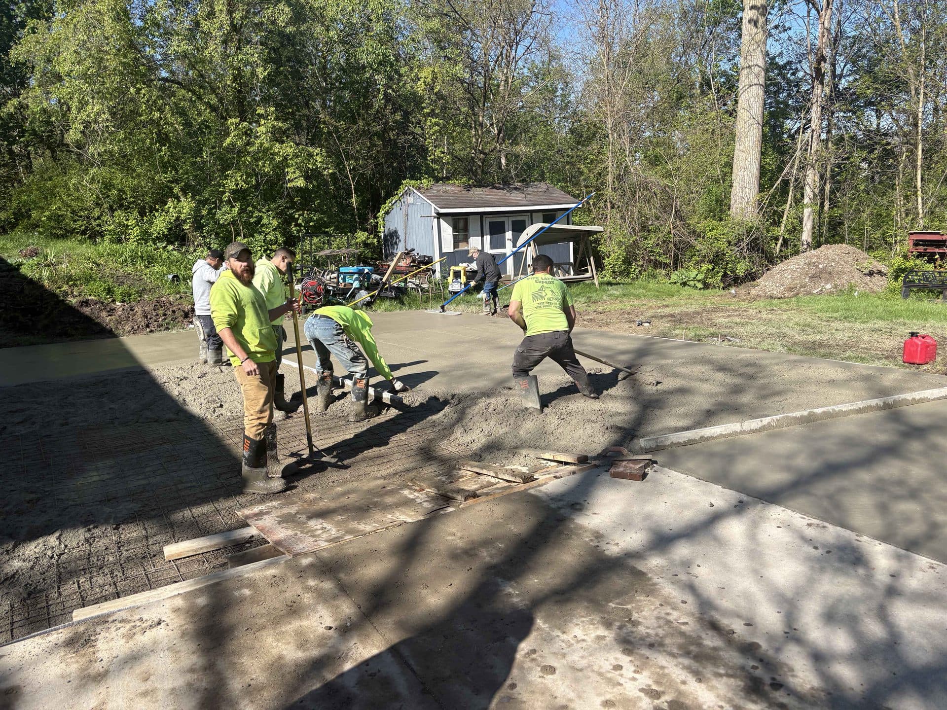 A crew finishing a large fresh concrete slab