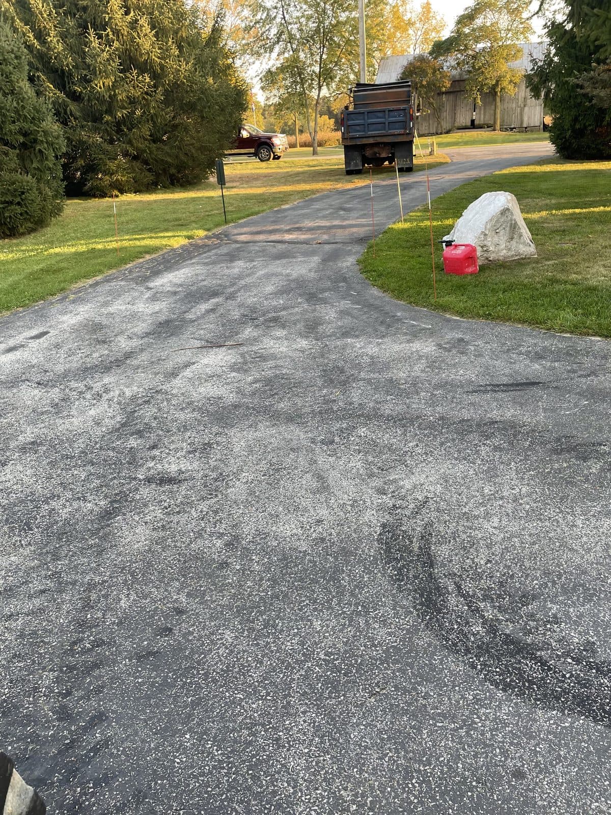 A freshly laid and graded gravel driveway curving up to a property