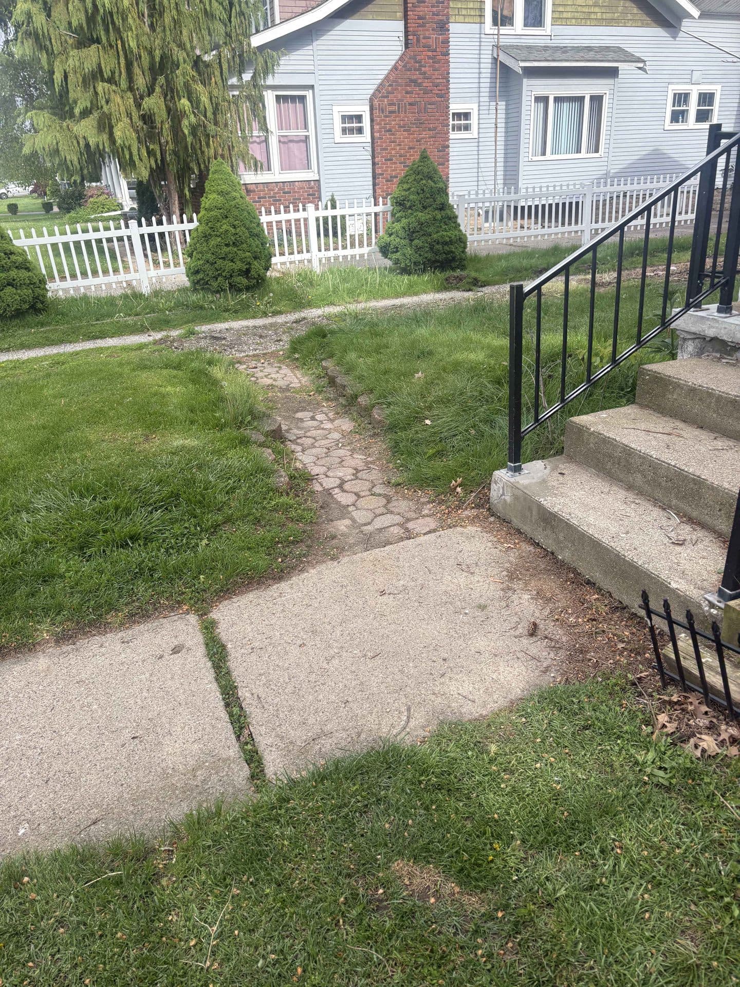 An old, cracked and uneven concrete walkway before replacement