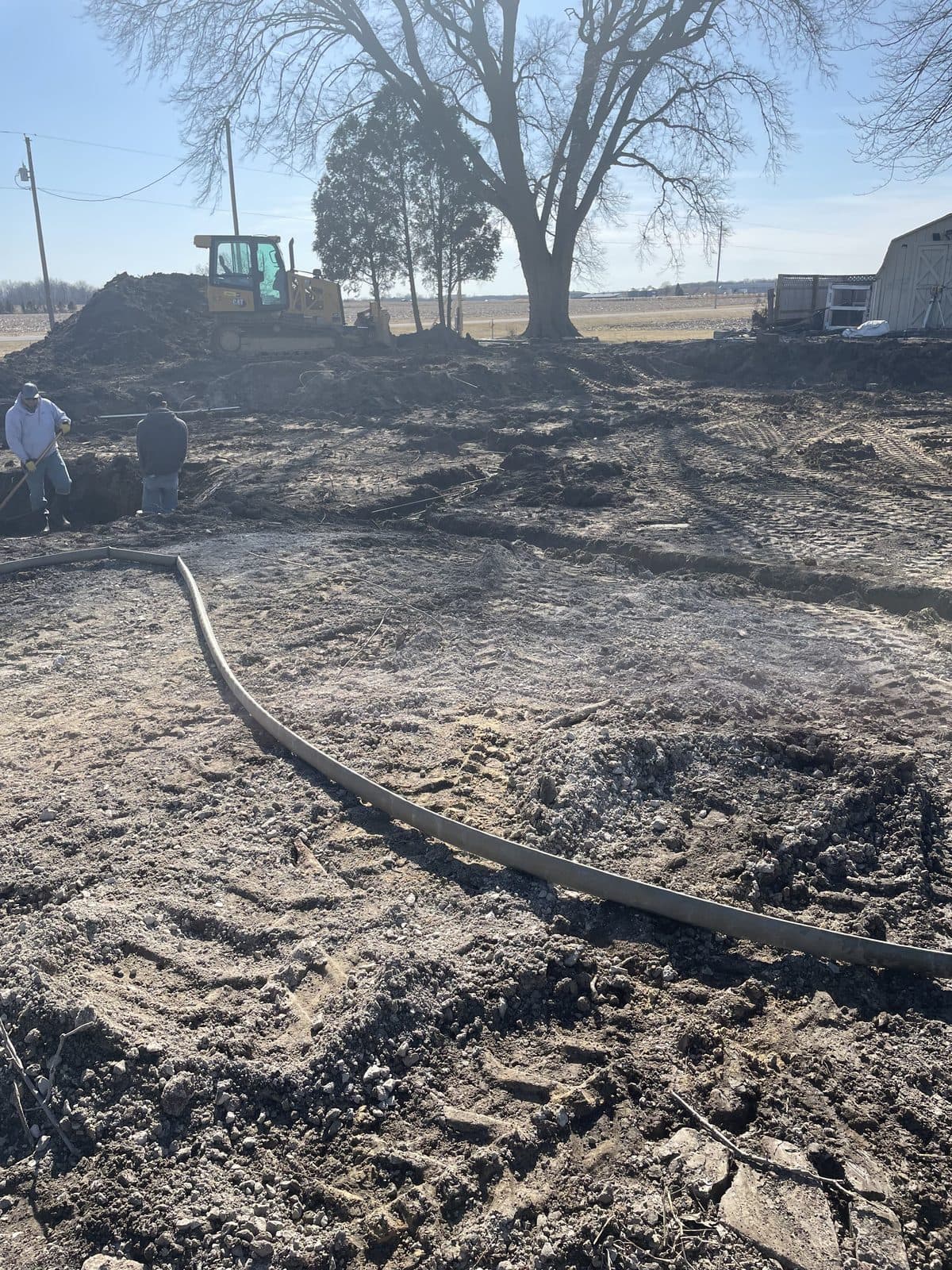 A dirt lot cleared and graded level with a container on site